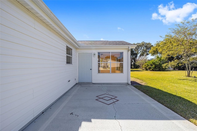 doorway to property with a yard and a patio