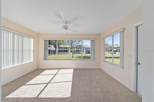 unfurnished sunroom with ceiling fan