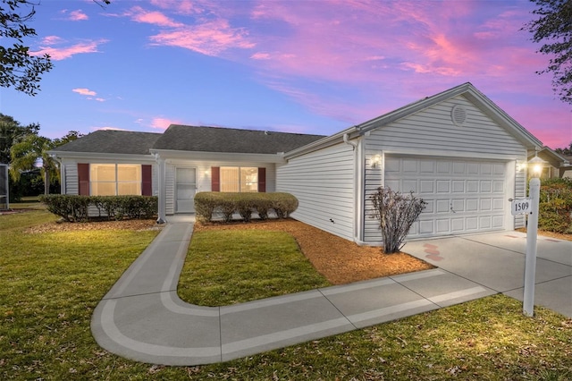 single story home featuring a garage and a lawn