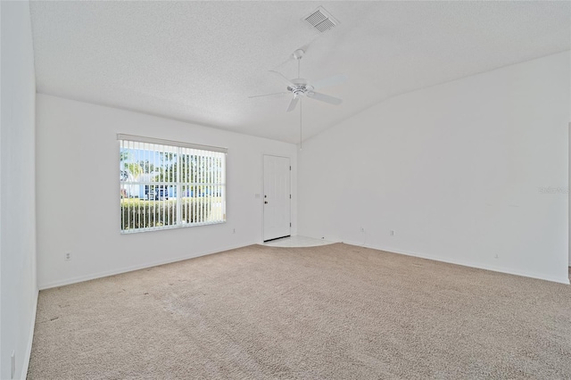 carpeted spare room featuring a textured ceiling, ceiling fan, and lofted ceiling