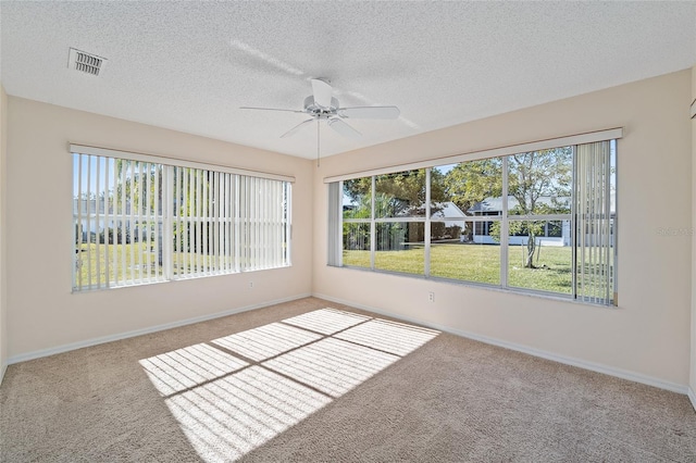 unfurnished room with ceiling fan, a textured ceiling, and carpet flooring