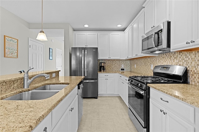 kitchen featuring decorative light fixtures, white cabinetry, sink, and appliances with stainless steel finishes