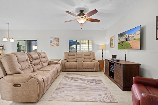 tiled living room featuring a textured ceiling and ceiling fan with notable chandelier