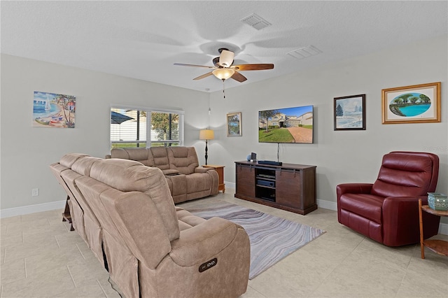 living room with ceiling fan and a textured ceiling