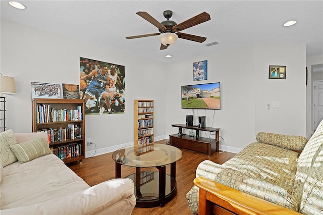 living room with hardwood / wood-style floors, ceiling fan, and a textured ceiling