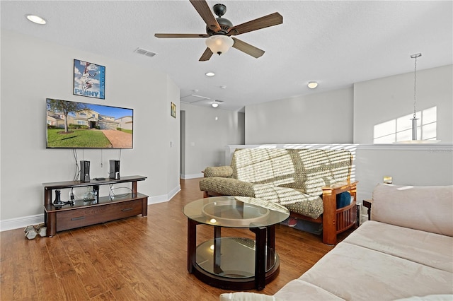 living room with ceiling fan, hardwood / wood-style floors, and a textured ceiling