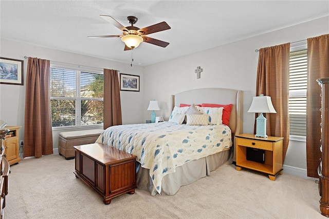 bedroom featuring light carpet, multiple windows, and ceiling fan