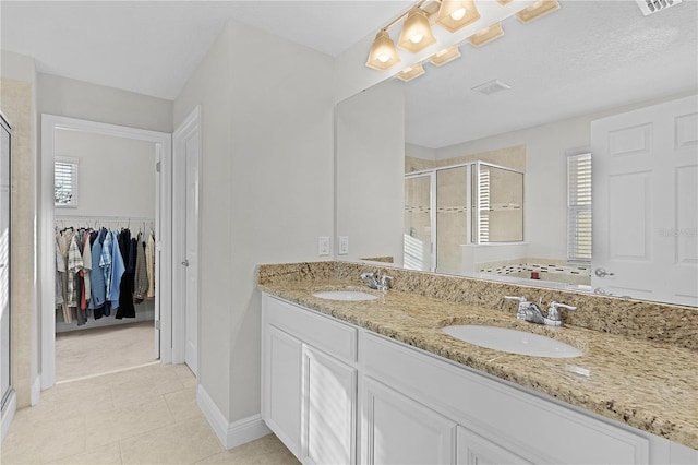 bathroom with tile patterned floors, vanity, and an enclosed shower