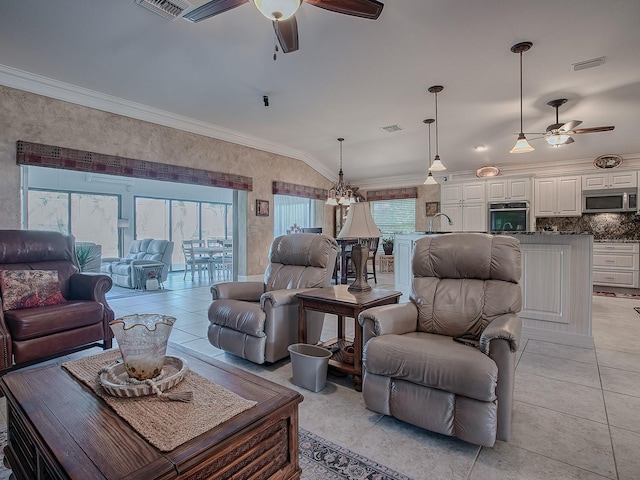 living room with ceiling fan with notable chandelier, light tile patterned flooring, lofted ceiling, and crown molding