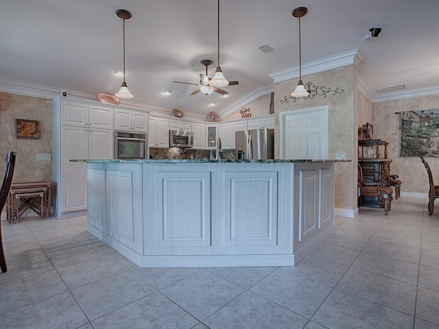 kitchen with white cabinets, pendant lighting, vaulted ceiling, and appliances with stainless steel finishes