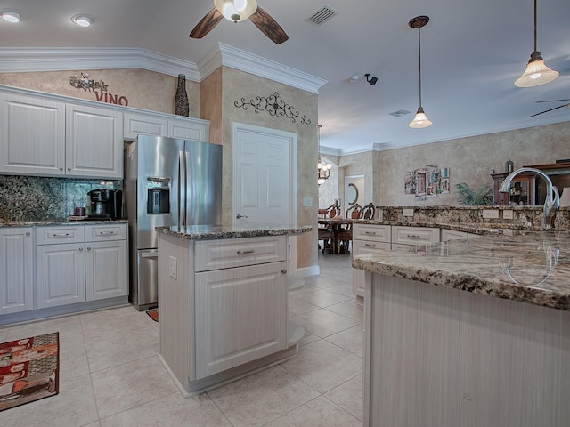 kitchen featuring ornamental molding, dark stone counters, pendant lighting, stainless steel fridge with ice dispenser, and white cabinetry