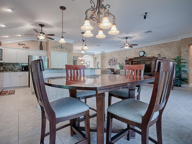 tiled dining space with lofted ceiling, crown molding, and ceiling fan with notable chandelier