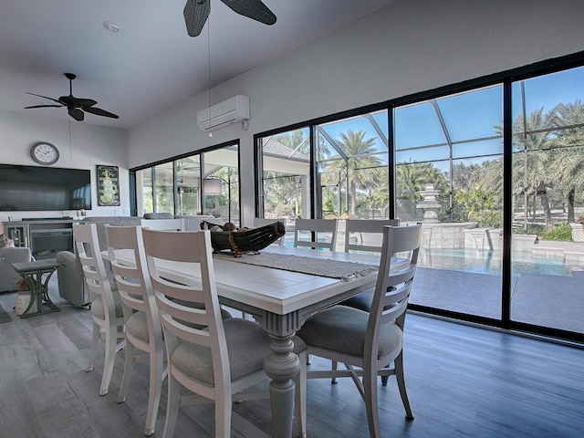 dining room featuring a wall mounted air conditioner, hardwood / wood-style flooring, plenty of natural light, and ceiling fan