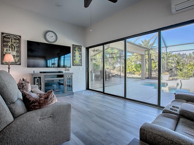 living room featuring a wall mounted air conditioner, hardwood / wood-style floors, and ceiling fan