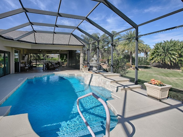 view of swimming pool with a patio area, ceiling fan, pool water feature, and glass enclosure