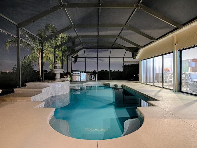 view of swimming pool with glass enclosure and a patio area