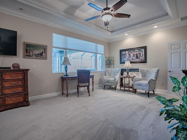 living area featuring light carpet, a tray ceiling, ceiling fan, and crown molding