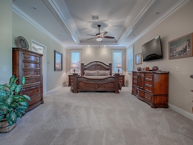 carpeted bedroom with ceiling fan, crown molding, and a tray ceiling