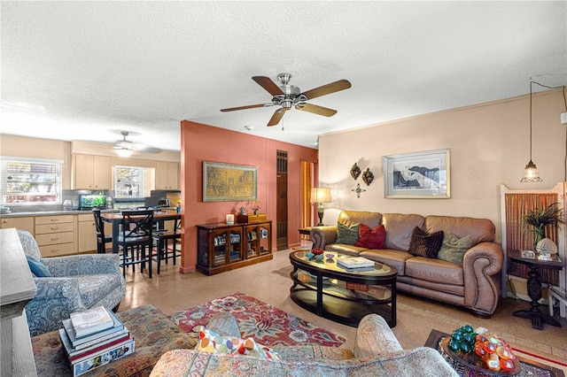 living room with ceiling fan and a textured ceiling