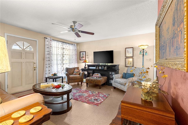 living room with a textured ceiling and ceiling fan