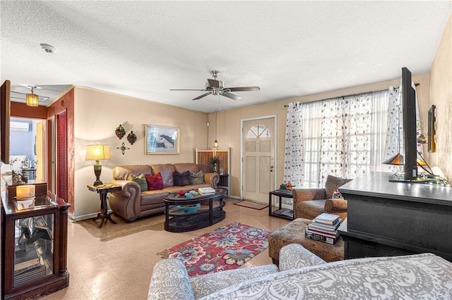 living room with a wall unit AC, ceiling fan, and a textured ceiling