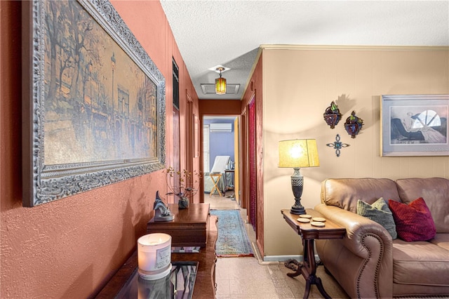 hall with a wall mounted air conditioner, a textured ceiling, and ornamental molding