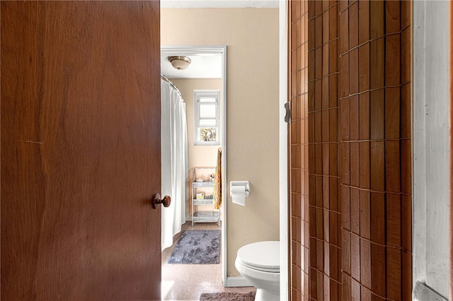 bathroom featuring curtained shower and toilet