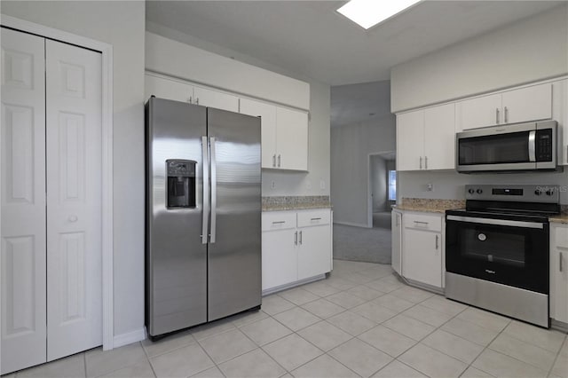 kitchen featuring white cabinets, light tile patterned flooring, and appliances with stainless steel finishes