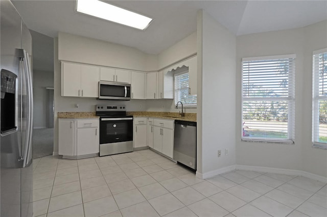 kitchen with white cabinets, light tile patterned flooring, and appliances with stainless steel finishes