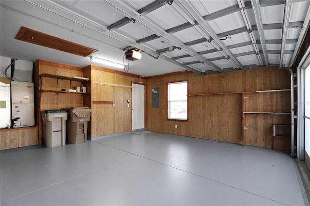 garage with electric panel, a garage door opener, wooden walls, and heating unit