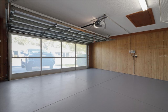 garage featuring wood walls and a garage door opener