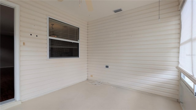 unfurnished sunroom with ceiling fan