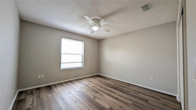 spare room with hardwood / wood-style floors, a textured ceiling, and ceiling fan