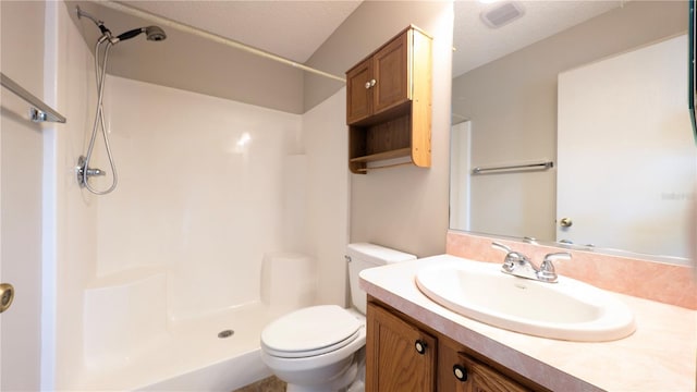 bathroom with walk in shower, vanity, and toilet