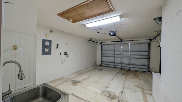 garage featuring a garage door opener, sink, and electric panel