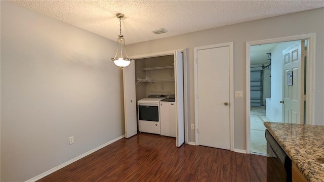 3449 Roanoke St, The Villages, FL 32162 - clothes washing area with washing machine and dryer, a textured ceiling, dark wood finished floors, laundry area, and visible vents