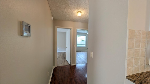 3449 Roanoke St, The Villages, FL 32162 - corridor featuring baseboards, dark wood-style flooring, and a textured ceiling