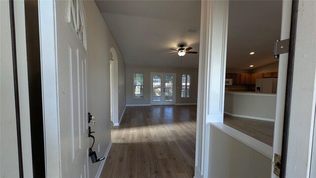 hall featuring hardwood / wood-style flooring, vaulted ceiling, and french doors