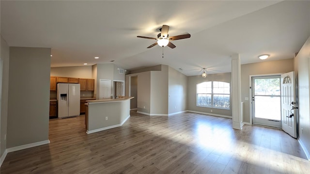 unfurnished living room featuring hardwood / wood-style flooring, ceiling fan, and vaulted ceiling