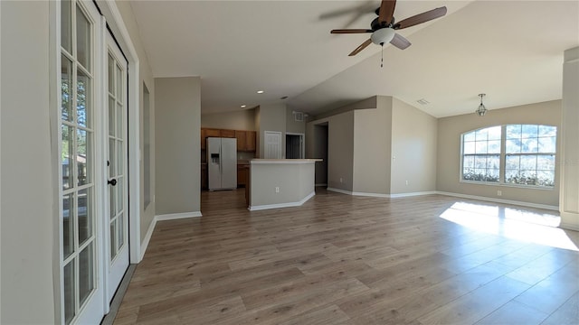 unfurnished living room featuring hardwood / wood-style flooring, vaulted ceiling, and ceiling fan