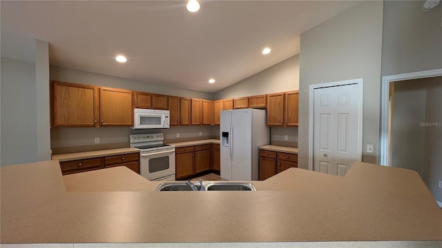 kitchen with vaulted ceiling, white appliances, and sink