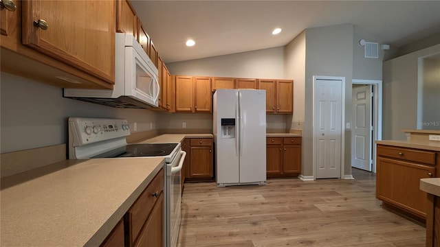 kitchen with white appliances, lofted ceiling, and light wood-type flooring