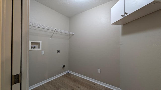 washroom with cabinets, electric dryer hookup, hookup for a washing machine, and light hardwood / wood-style flooring