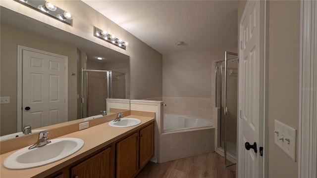 bathroom featuring hardwood / wood-style flooring, vanity, independent shower and bath, and a textured ceiling