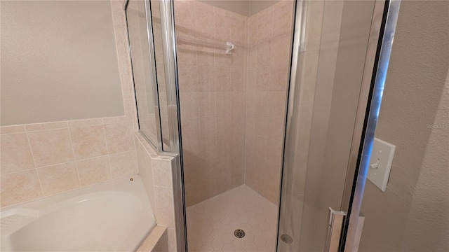 bathroom featuring shower with separate bathtub