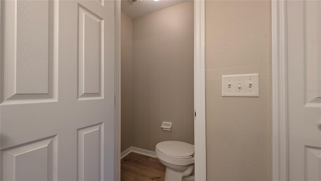 bathroom featuring hardwood / wood-style floors and toilet