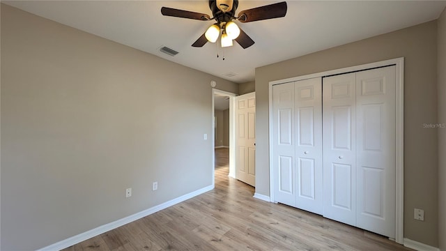 unfurnished bedroom featuring ceiling fan, light hardwood / wood-style floors, and a closet