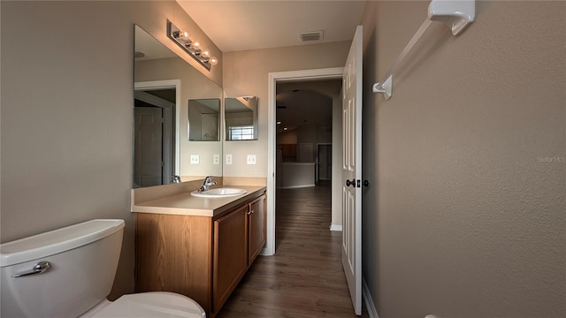 bathroom featuring hardwood / wood-style flooring, vanity, and toilet