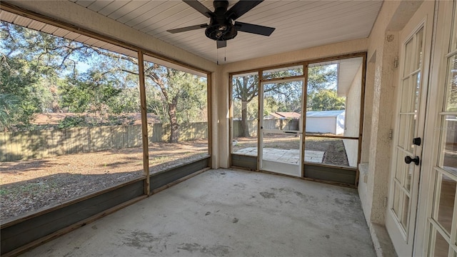 unfurnished sunroom featuring ceiling fan