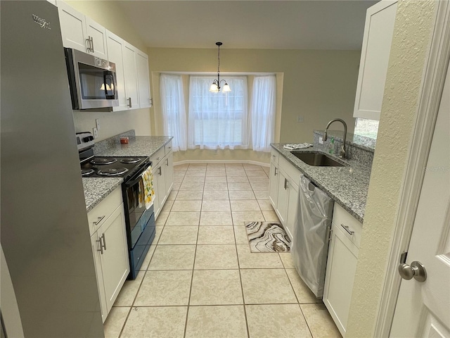 kitchen featuring appliances with stainless steel finishes, light stone counters, sink, pendant lighting, and white cabinetry